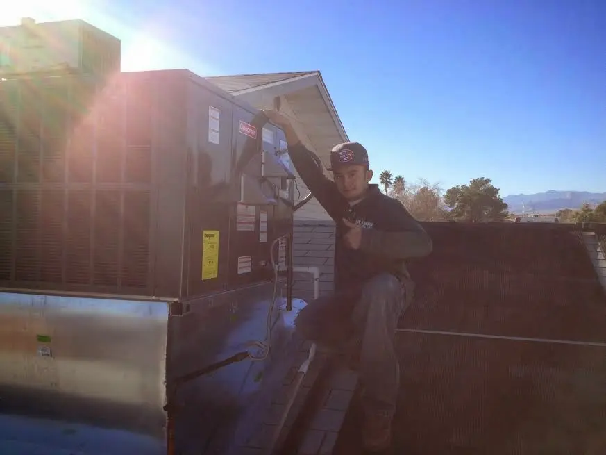 HVAC technician performing AC Tune-Up on a rooftop unit in Bath